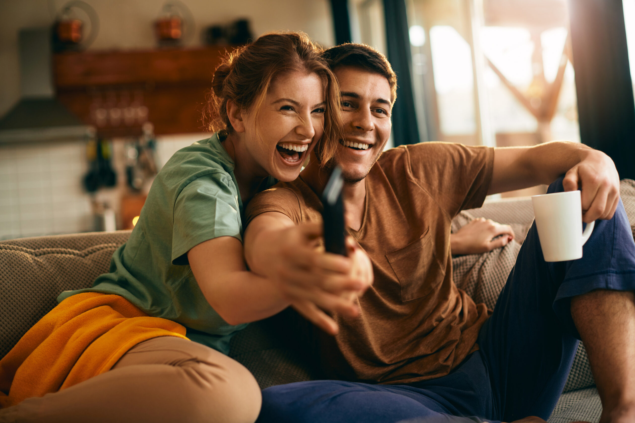Happy couple watching InfinityRec IPTV together on the couch