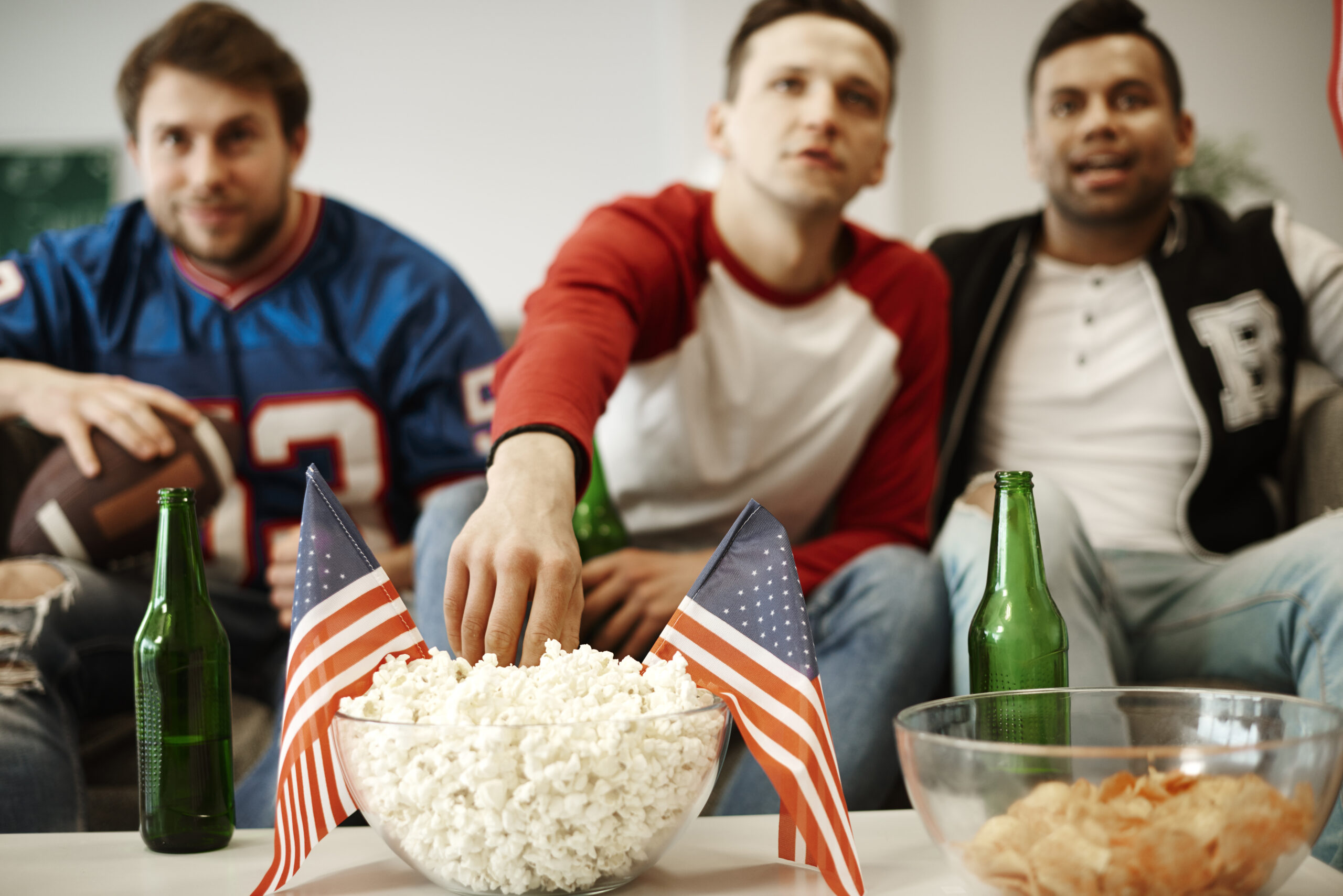 Group of friends watching live sports together using Infinity IPTV on a big screen