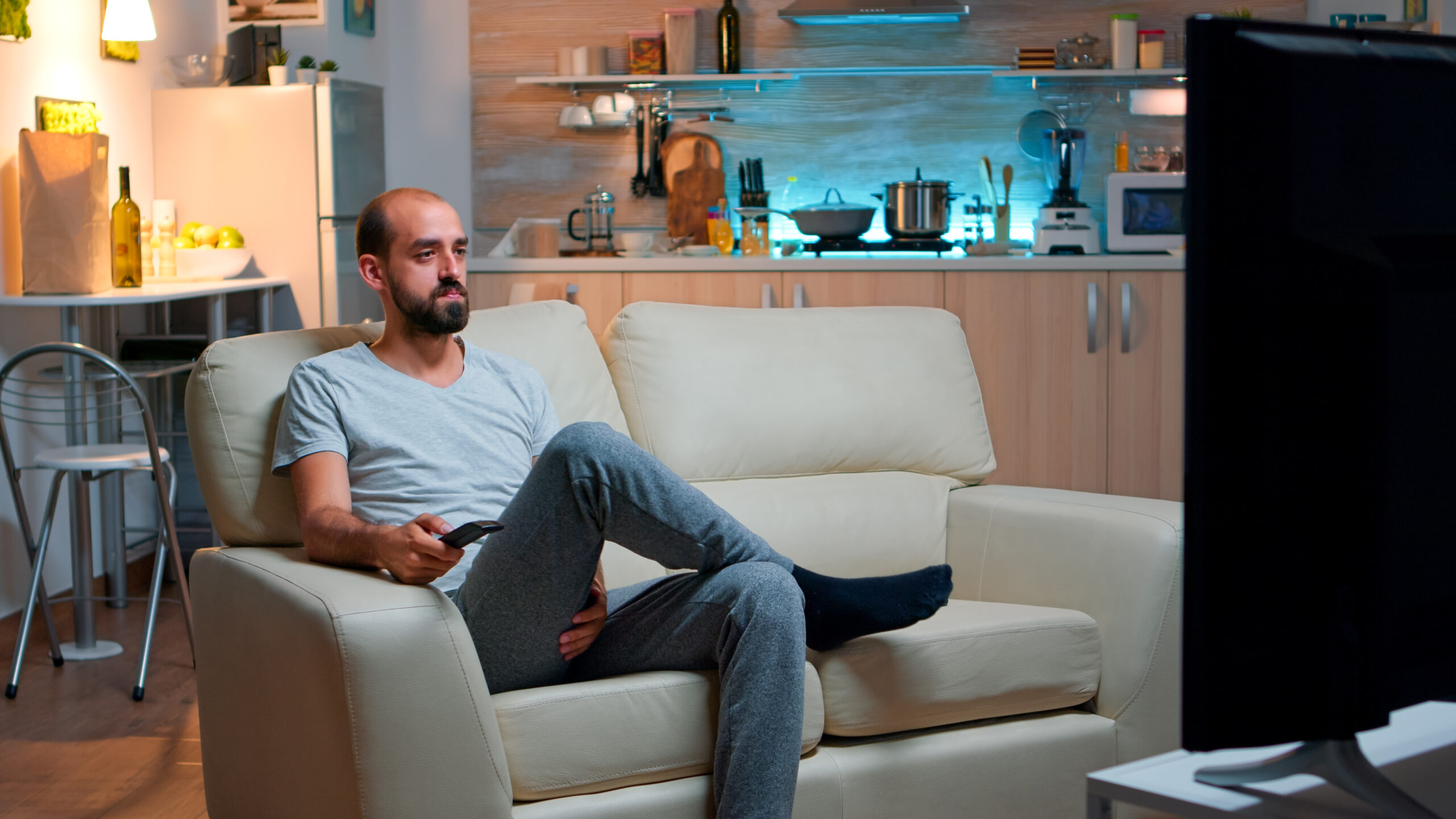 Man watching IPTV content on a large smart TV at home